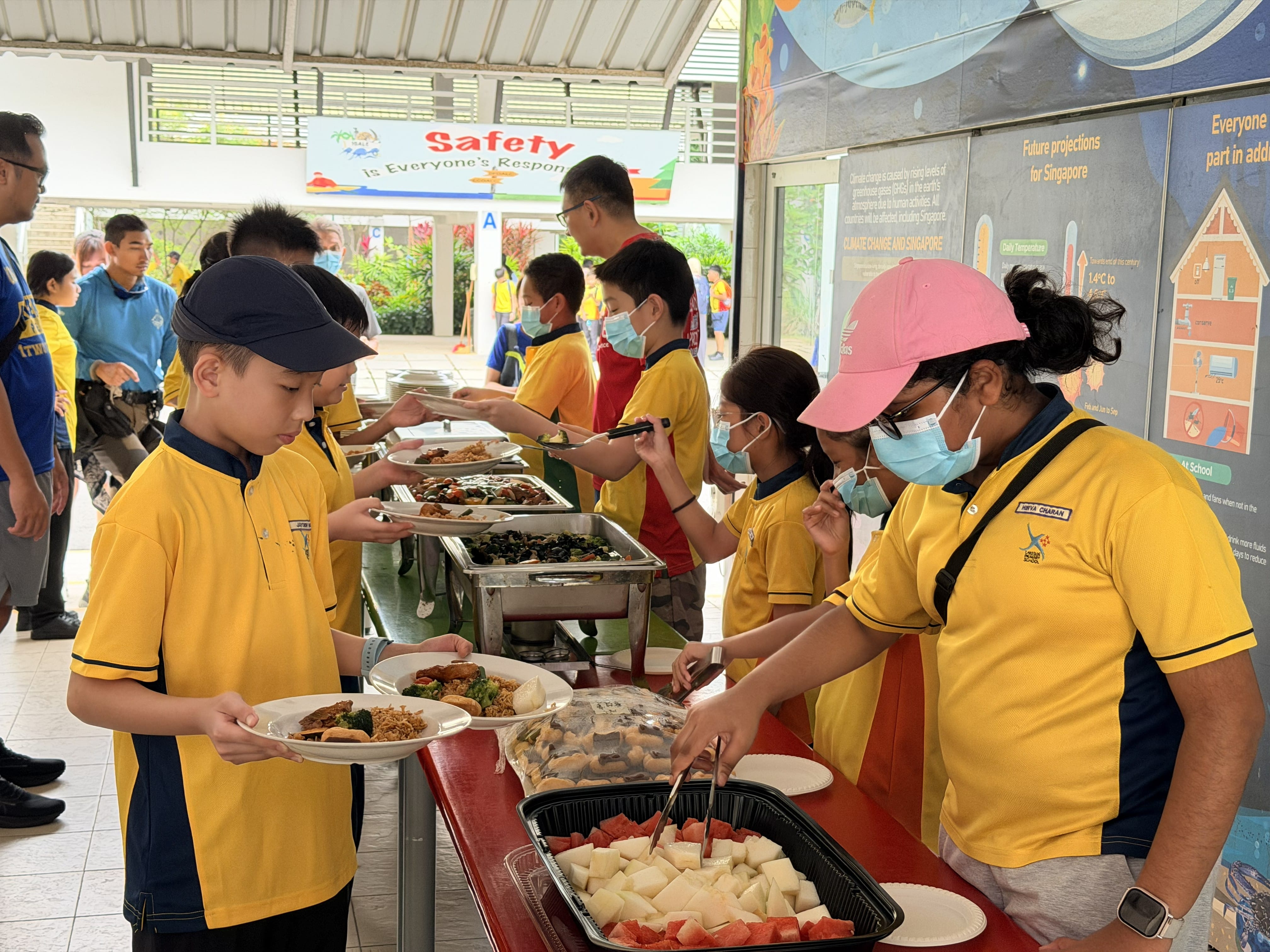 Students serve their friends food during mealtime